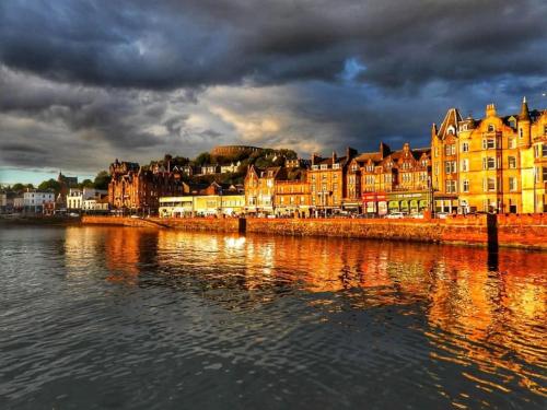a group of buildings on the shore of a body of water at 5 Oban in Oban