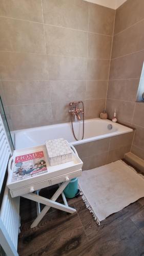 ein Badezimmer mit Badewanne und ein Buch auf dem Tisch in der Unterkunft Magisches Schlafzimmer in Hamburg