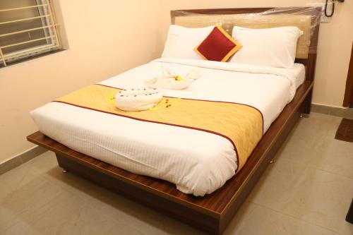 a bedroom with a bed with white sheets and pillows at Hotal Virinchi Ultra Comforts - Good Rooms - Brand New Building in Tirupati