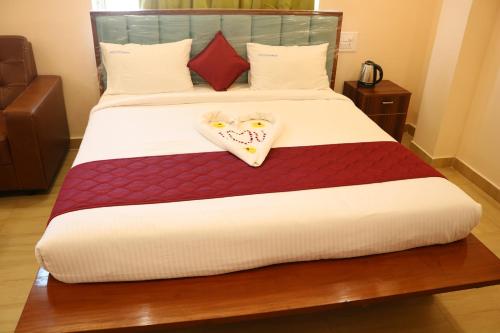 a bed with a heart shaped pillow on it at Hotal Virinchi Ultra Comforts - Good Rooms - Brand New Building in Tirupati