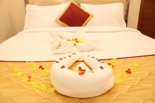 a bed with a white pillow with flowers on it at Hotal Virinchi Ultra Comforts - Good Rooms - Brand New Building in Tirupati
