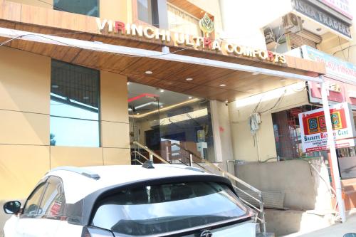 a white car parked in front of a building at Hotal Virinchi Ultra Comforts - Good Rooms - Brand New Building in Tirupati