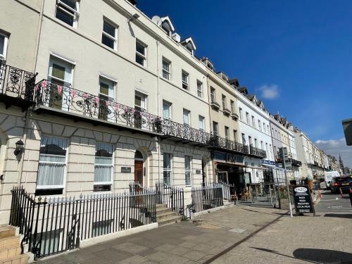 a large white building with balconies on a street at Bay Retreat - Esplanade sea views parking in Weymouth