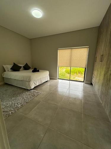 a bedroom with a bed and a window at Sakkie se Dakkie in Agulhas