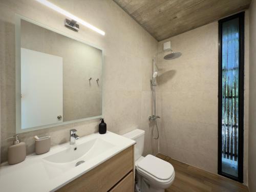 a bathroom with a sink and a toilet and a mirror at Terrazas del Bosque in La Pedrera