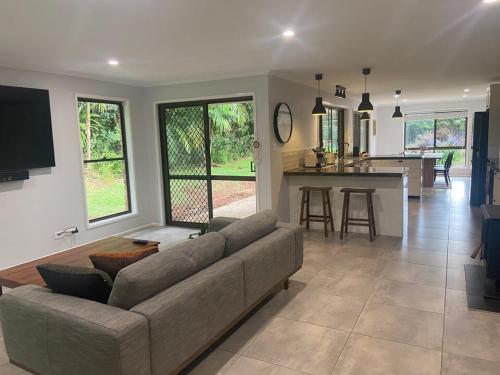 a living room with a couch and a kitchen at The Mountain House in Mount Tamborine