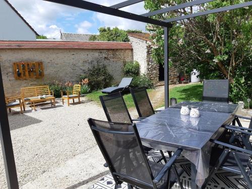 un patio con tavolo e sedie in un cortile di Studio au calme à la campagne 2, 4 ou 6 personnes a Denonville