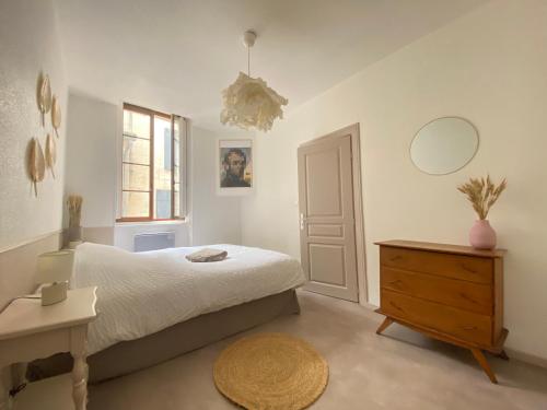 une chambre avec un lit, une commode et un miroir dans l'établissement Logement Cosy à Périgueux avec 2 Chambres, Wifi fibre, à Périgueux