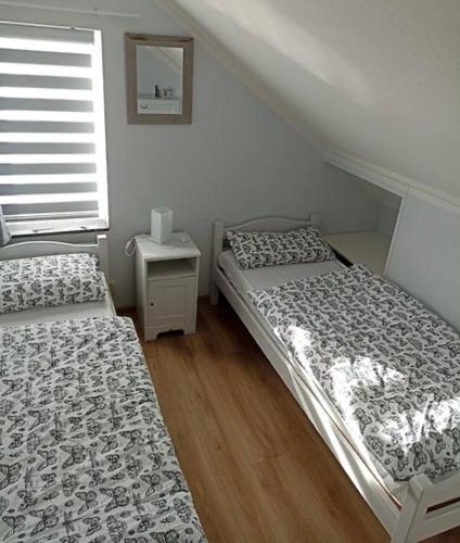 two beds in a small room with a window at Ferienhaus Fridolin Fort Soleil 27, Breskens Zeeland in Breskens
