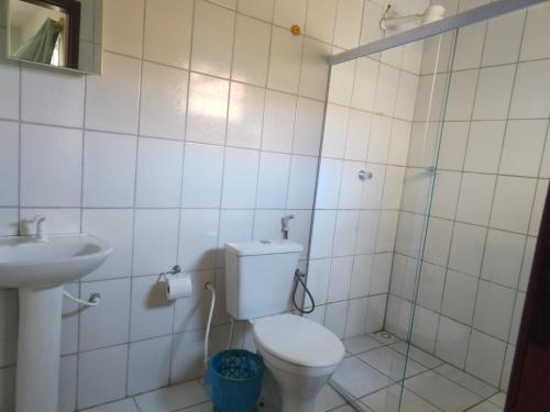 a bathroom with a toilet and a sink at Aquarela Suítes in Piúma