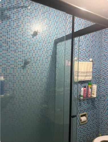 ein blau gefliestes Badezimmer mit Dusche und Glastür in der Unterkunft Melhor Custo BENEFICIO DO RECIFE in Recife