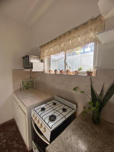 a small kitchen with a stove and a window at Casa con cochera doble y parrillero en zona estratégica in Villa Krause