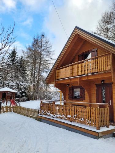 a log cabin with a deck in the snow at Poranek Pieniński in Krościenko