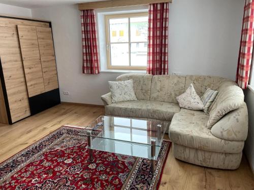 a living room with a couch and a glass table at Buck Chalet in Steeg