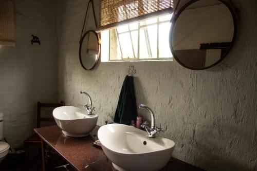 a bathroom with two sinks and a mirror at The Stables in Ghanzi