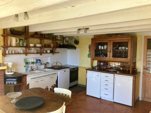 - une cuisine avec des appareils blancs et une table en bois dans l'établissement Chambres d'Hôtes de la Treille, à La Chapelle-Montbrandeix