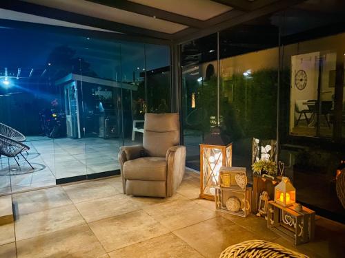 a living room with a chair and a table at LuxChalet Ferienhaus ELLA mit Aussicht auf die Ijssel im Ferienpark mit Pool und Strand Holland Niederlande in Lathum