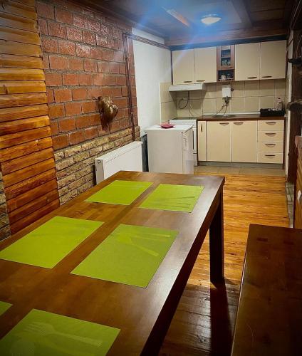 a kitchen with a wooden table with greenprints on it at Apartman Zlatarske Čari in Nova Varoš