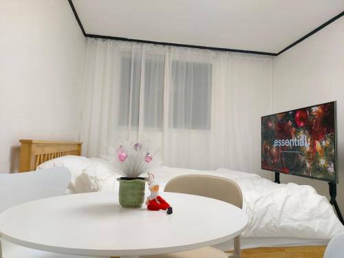 a white room with a white table and a tv at Mokdong Stay in Seoul