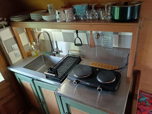 a miniature kitchen with a sink and a stove at Roulotte in Ginals