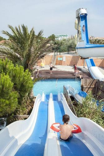 - un homme à bord d'un toboggan aquatique dans un parc aquatique dans l'établissement Mobile-Home 6 pers Camping 4 Etoiles 66140 Idéal Familles, à Canet