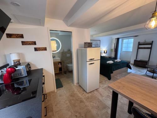 a kitchen and a living room with a refrigerator at Escapade à Pommard in Pommard