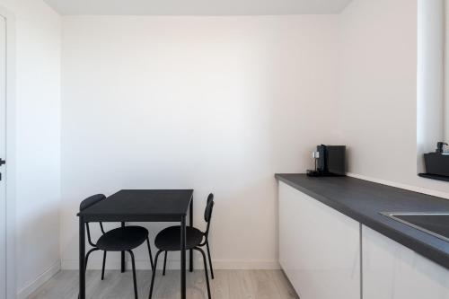 a black table and two chairs in a kitchen at AeroPrime - LOFT in Tunari