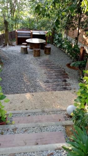 a stone path with a table and benches in a garden at The Wildwood Retreat KKB in Kuala Kubu Baharu