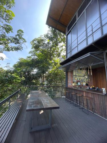 a wooden deck with a table and a bar at The Wildwood Retreat KKB in Kuala Kubu Baharu