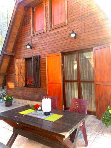a wooden house with a wooden table and chairs at Apartman Zlatarske Čari in Nova Varoš
