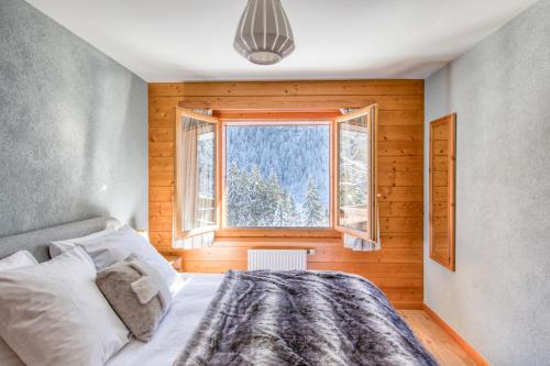 a bedroom with a bed in front of a window at Champcalme 5 And Its Exclusive Views in Champéry