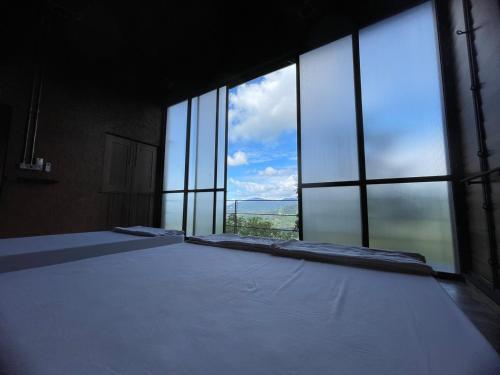 a large room with large windows with a view of the sky at The Wildwood Retreat KKB in Kuala Kubu Baharu
