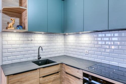 a kitchen with a sink and white tiles at Champcalme 5 And Its Exclusive Views in Champéry