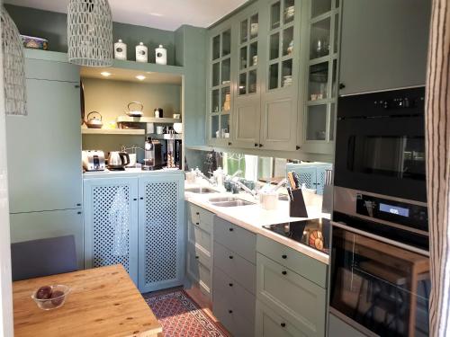 une cuisine avec des armoires blanches et une table à l'intérieur dans l'établissement Aix centre, 2 room apartment garden, parking, à Aix-en-Provence