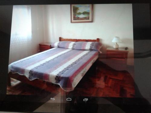 a bedroom with a bed with a striped blanket at Mardel REBAJADO living 1 dorm, 4 pers, gran terraza mzn peatonal in Mar del Plata