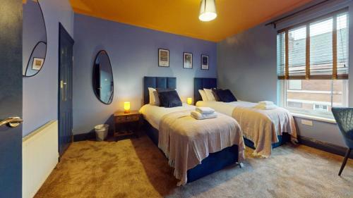 a blue room with two beds and a window at Unique 3Bed Home Free Parking Near Meadowhall in Brightside
