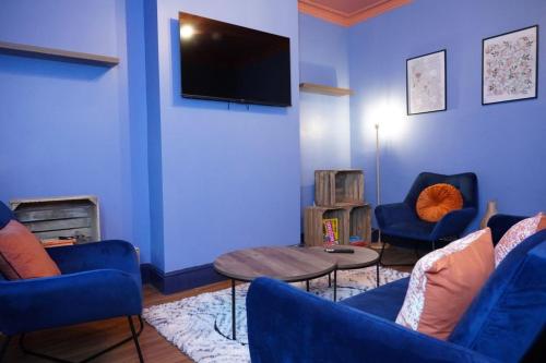 a living room with blue walls and blue chairs and a tv at Unique 3Bed Home Free Parking Near Meadowhall in Brightside