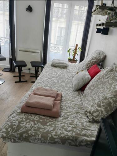 Cette chambre comprend un grand lit et un canapé. dans l'établissement Escale dans le haut Marais, à Paris