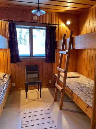 a room with two bunk beds and a chair at Åre, Trillevallen stuga Jakob in Trillevallen