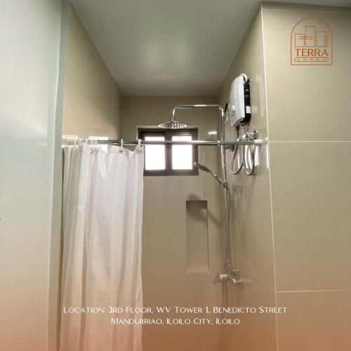 un bagno con doccia con tenda da doccia di Terra Condo a Città di Iloilo