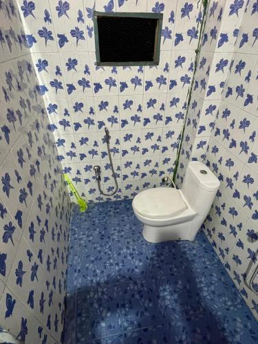 DigboiにあるMini Sweet Havenのトイレと青と白のタイルが敷かれたバスルーム