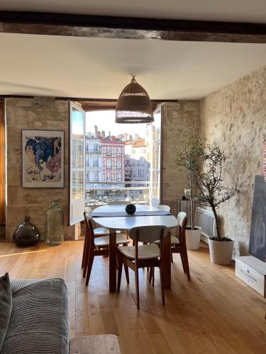 une salle à manger avec une table et des chaises et une fenêtre dans l'établissement Bayonne centre Grand appartement sur les quais, à Bayonne