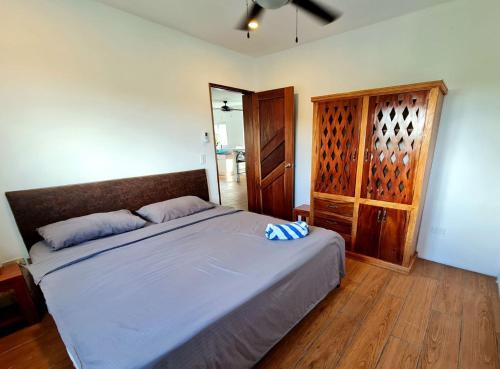 a bedroom with a large bed and a wooden cabinet at Tablas Seaview Homestay in Ferrol