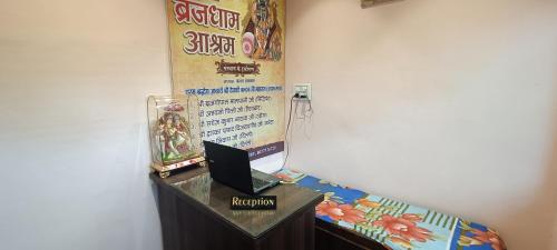 a table with a laptop on it next to a wall at Brij Dham in Vrindāvan