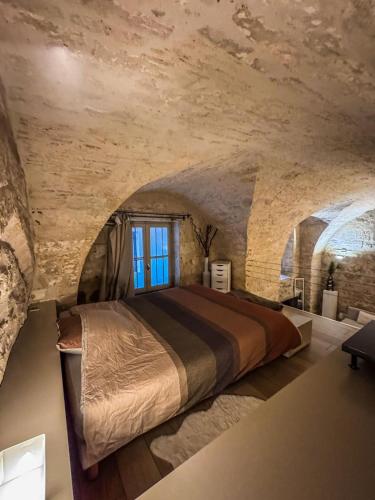 - une chambre en pierre avec un grand lit dans l'établissement L'Elegant - Hôtel Particulier Historique, à Montpellier