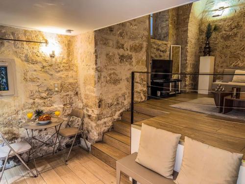 - un salon avec un mur en pierre et une table dans l'établissement L'Elegant - Hôtel Particulier Historique, à Montpellier