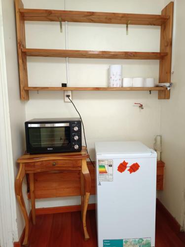 a microwave sitting on a table next to a refrigerator at Casa Cabaña independiente Lomas de Mirasur in Temuco