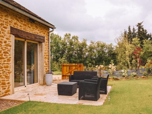 a patio with chairs and a table in a yard at Celon Nous - La Porcherie in Célon