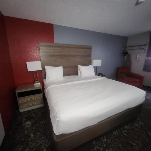 a bedroom with a large white bed and two lamps at Ramada by Wyndham Cedar Rapids South in Cedar Rapids