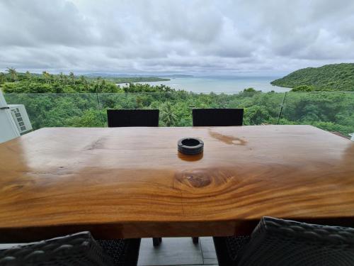 a wooden table with chairs with a view of the ocean at Tablas Seaview Homestay in Ferrol